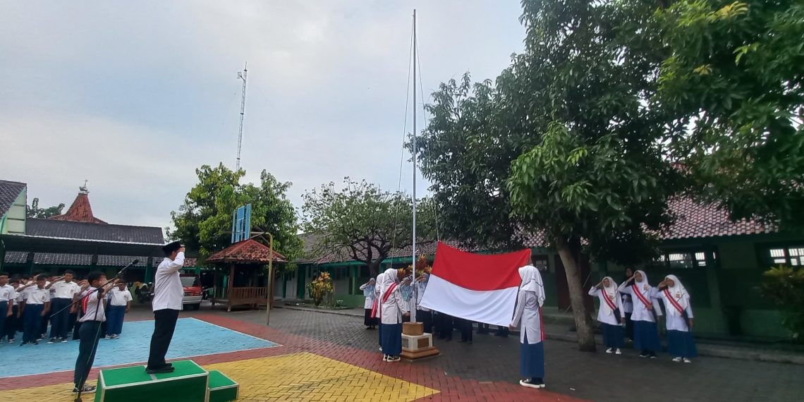 Meski Diguyur Hujan, MTsN 8 Sragen Penuh Semangat Laksanakan Upacara Bendera Hari Kebangkitan Nasional